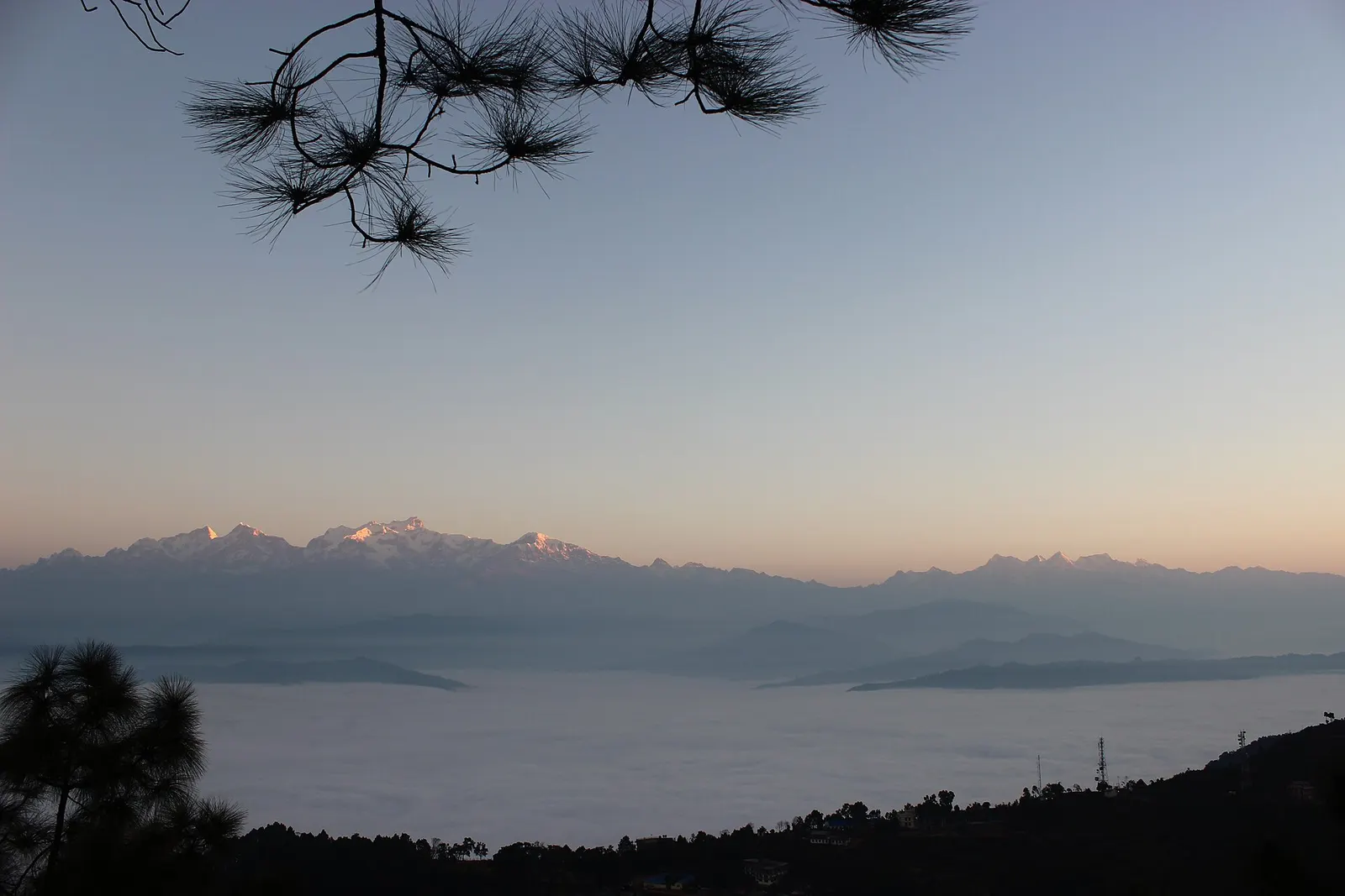 Faint snow peaks above a misty valley at first light, seen from Bandipur.