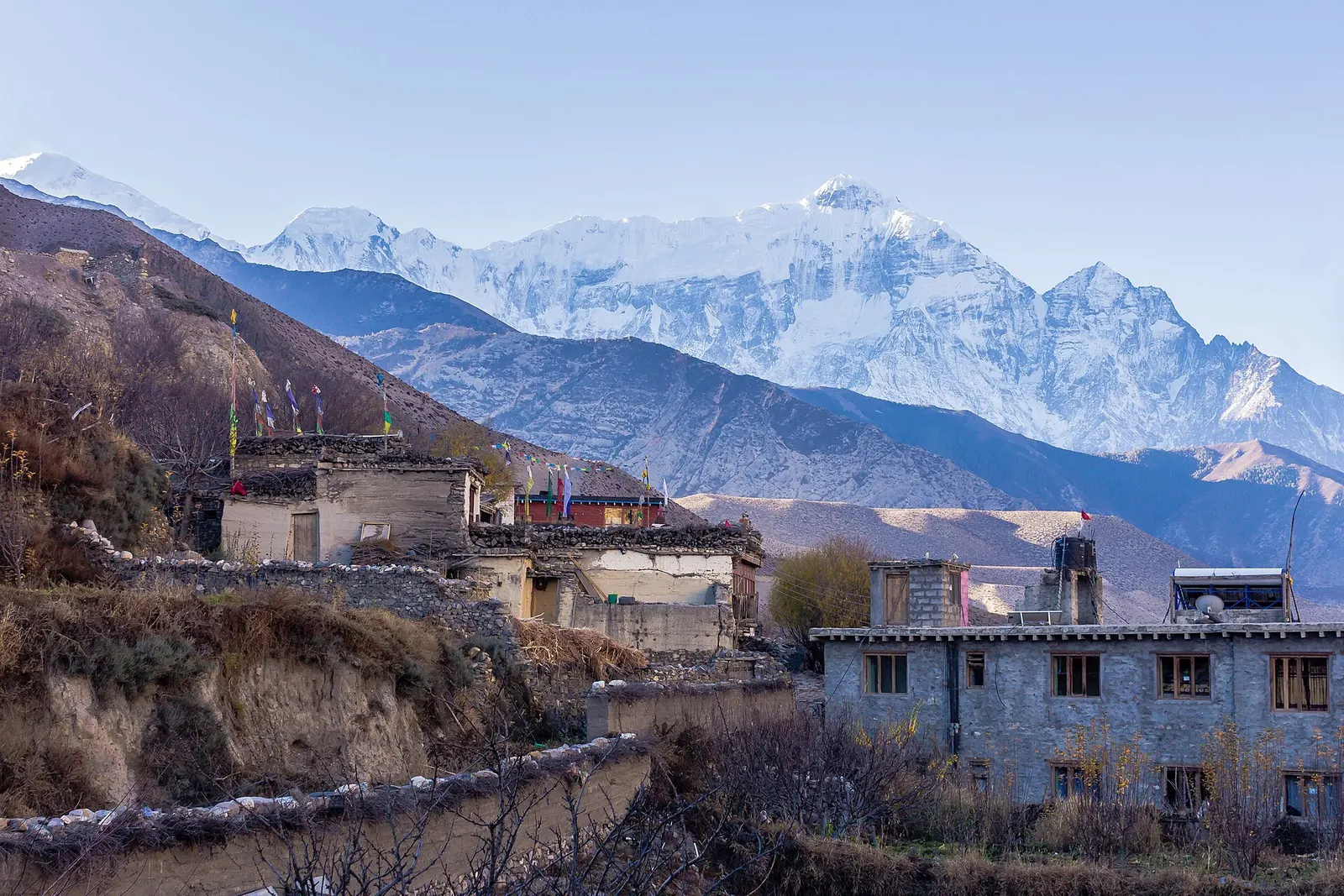 Mud-brick buildings of Kagbeni with snow-covered peaks behind.