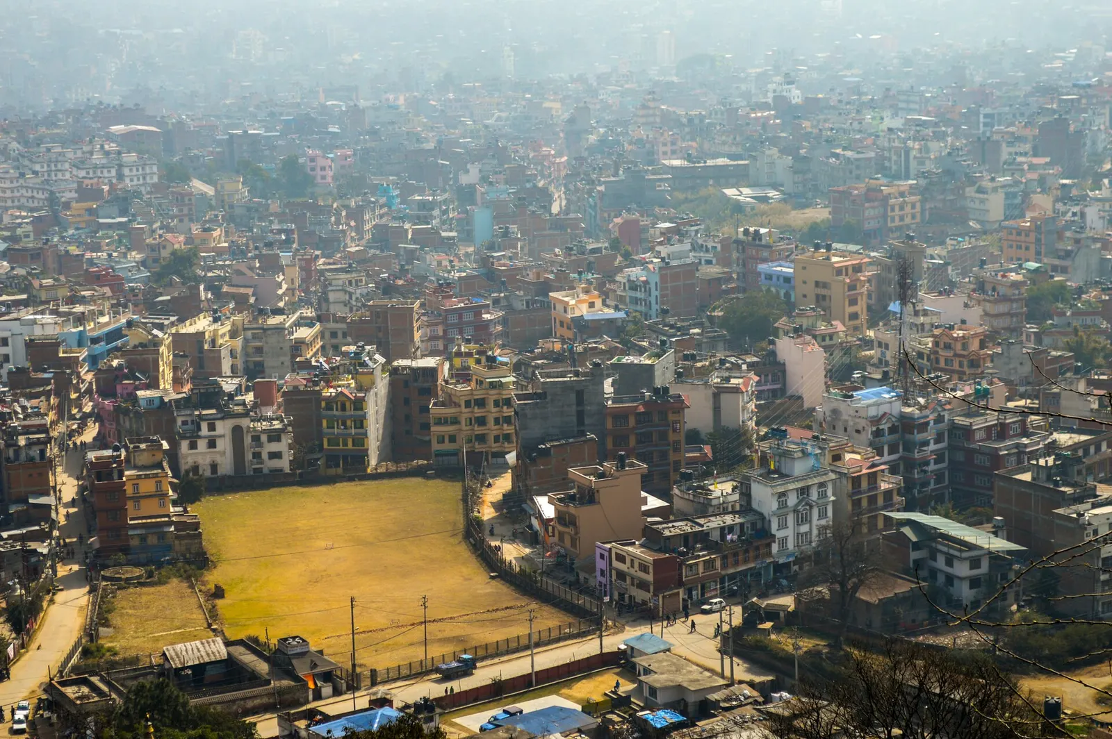 Rooftops of Kathmandu spreading across the valley floor, seen from above.