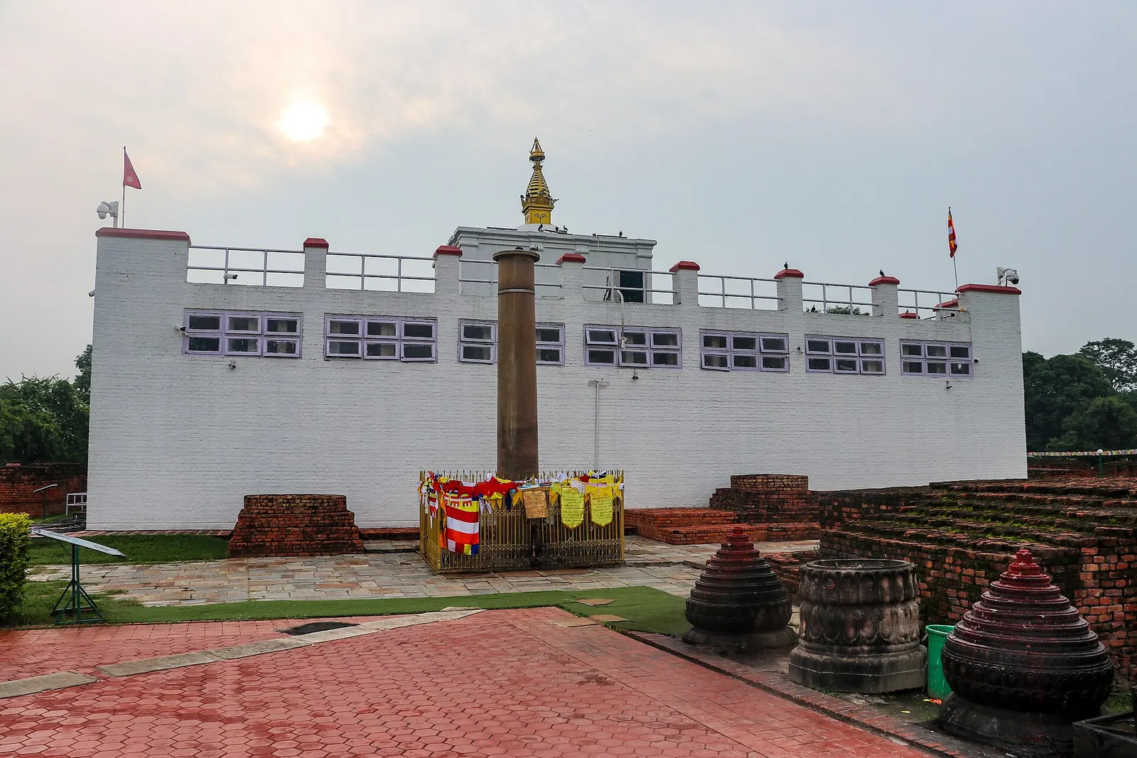 The white Maya Devi Temple and the Ashoka pillar in the Sacred Garden at Lumbini.