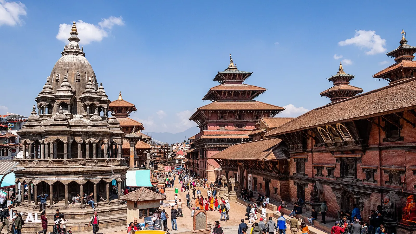 Tiered temples and the stone Krishna Mandir lining Patan Durbar Square in Lalitpur.