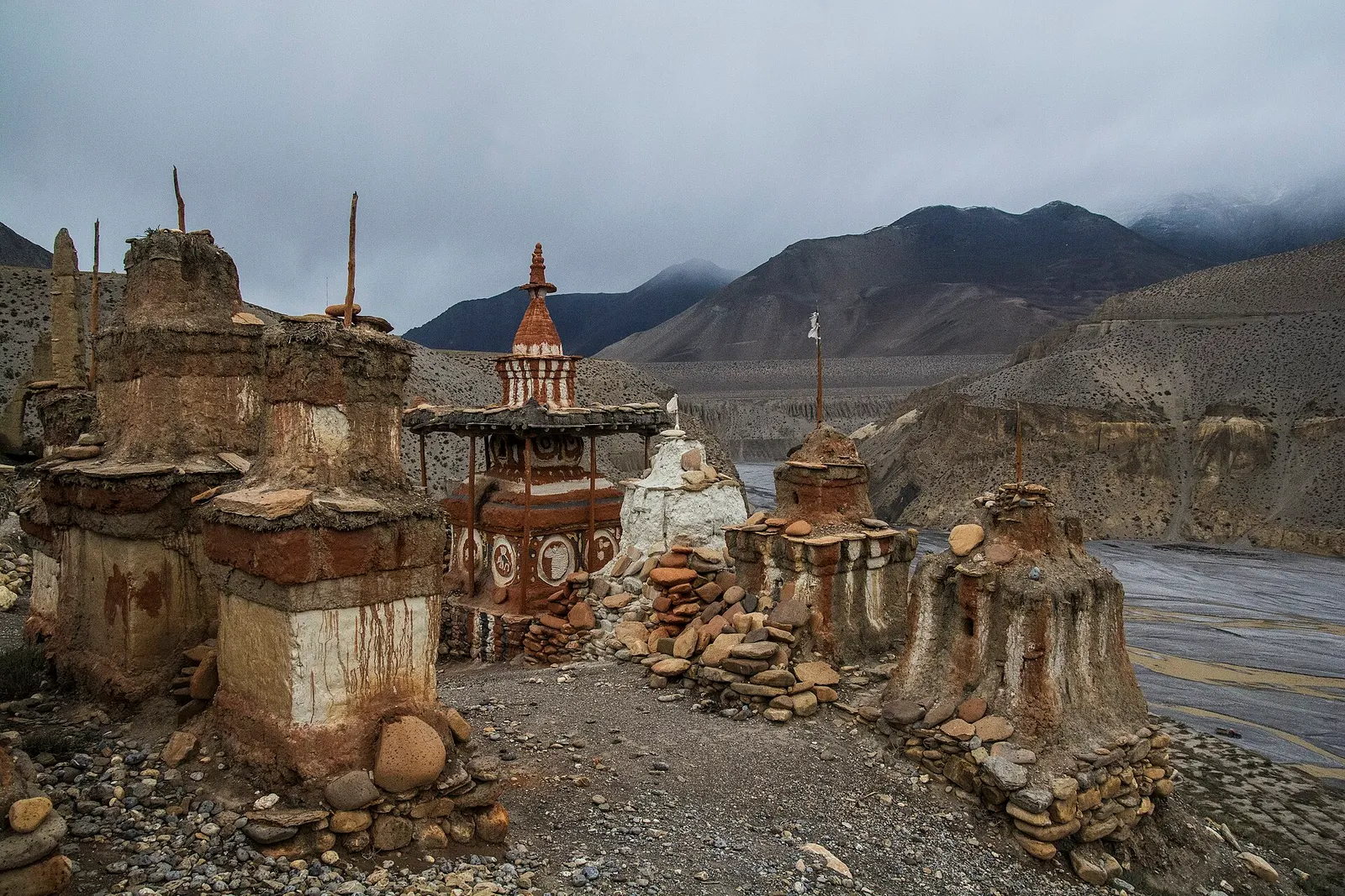 Weathered old chortens beside the wide Kali Gandaki riverbed under cloud in Upper Mustang.