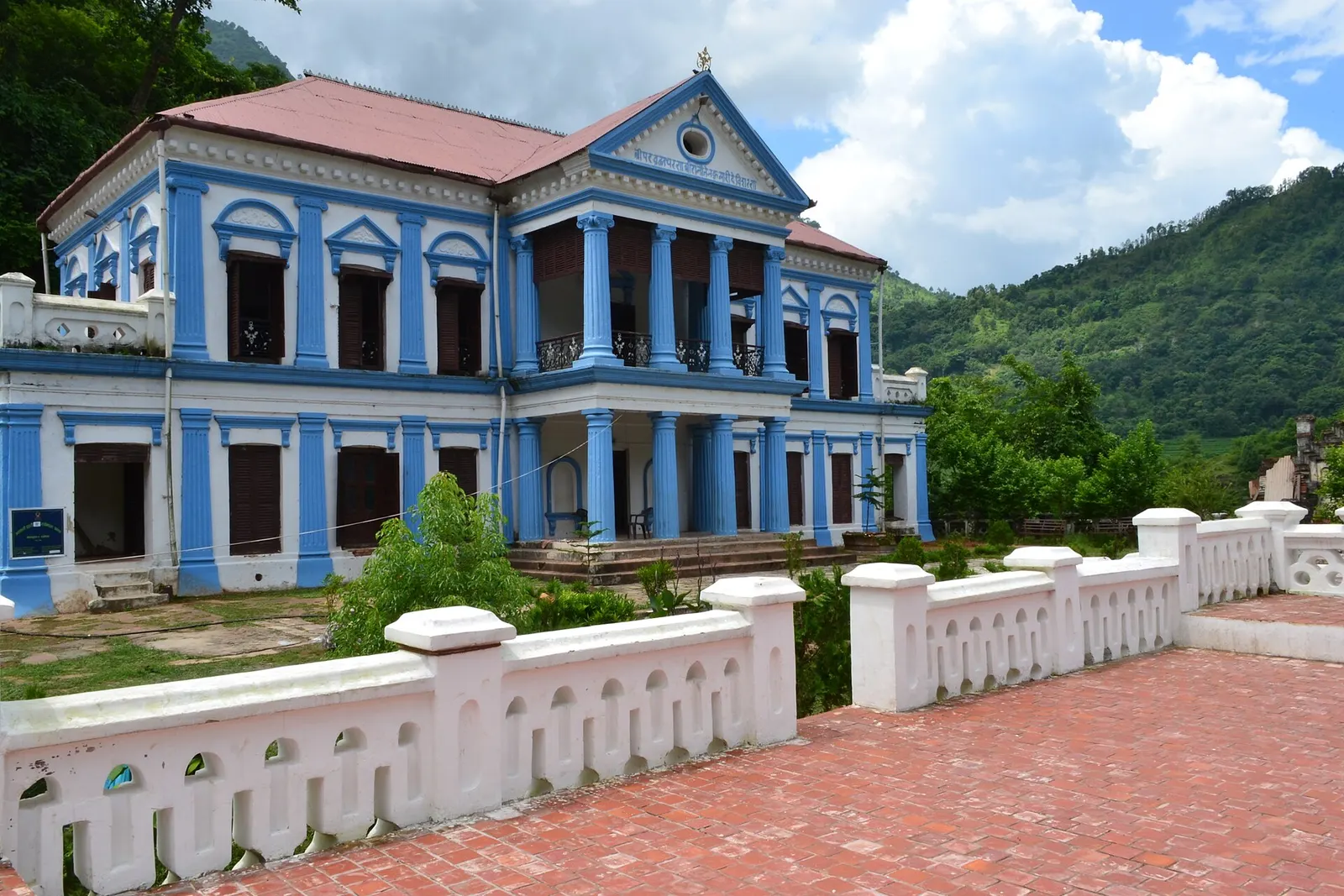 The blue-and-white columned facade of Rani Mahal with a balustraded terrace in front.